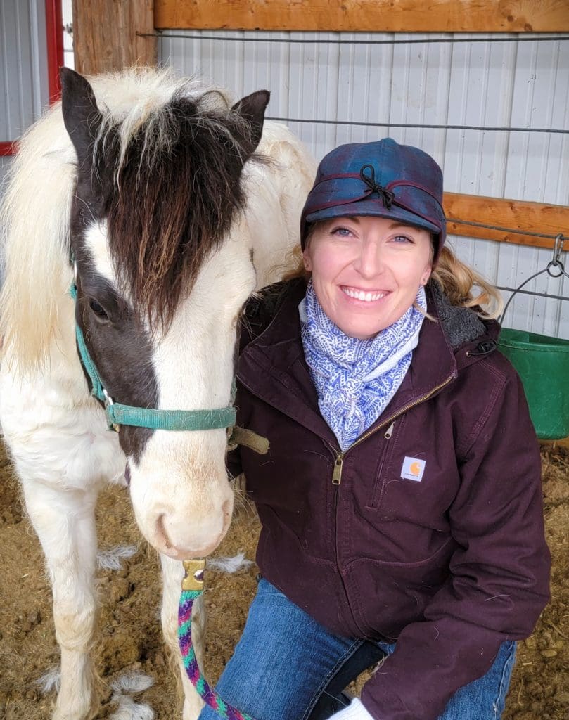 Dr. Rachel Shutter sitting with a horse.